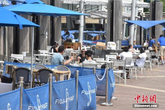 资料图：当地时间5月29日，美国首都华盛顿正式“解封”，包括餐厅室外座位、理发店、公园等“开门”。图为民众在餐厅室外座位保持“社交距离”用餐。
/p中新社记者 沙晗汀 摄